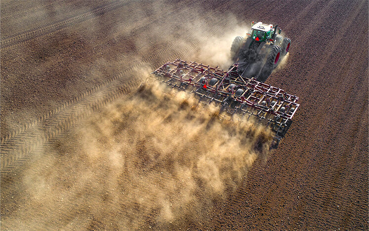 Tractor tilling on a field.