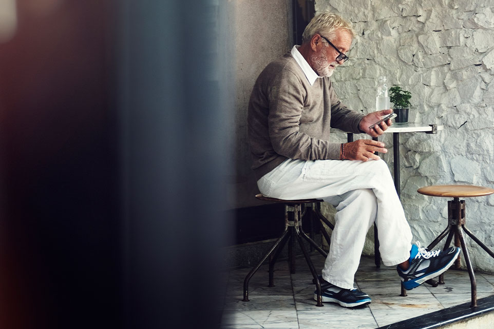 Elderly man looking at his bank account on his mobile phone.