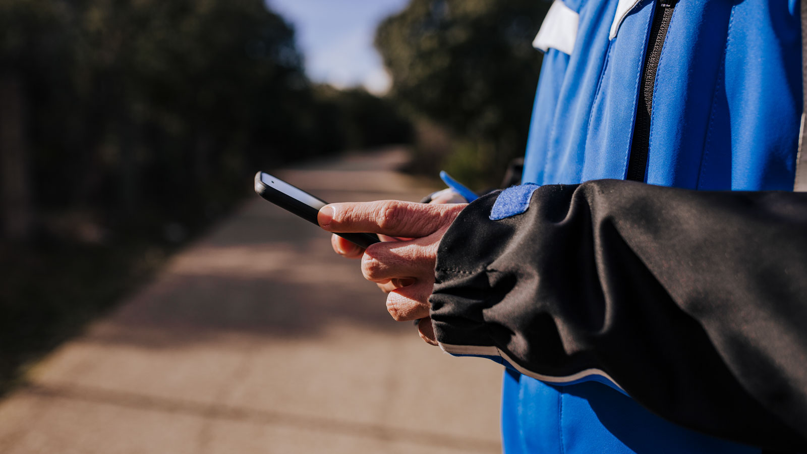 A person checking their mobile banking app while on a run.