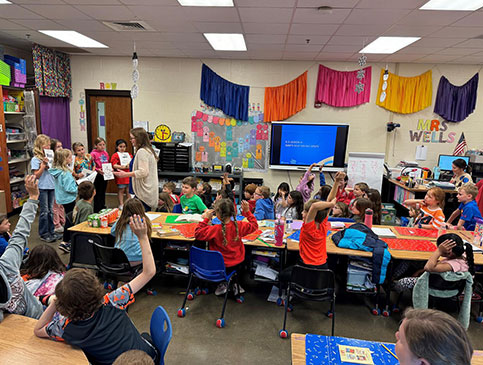 Armor Bank Team member reading to a group of children.