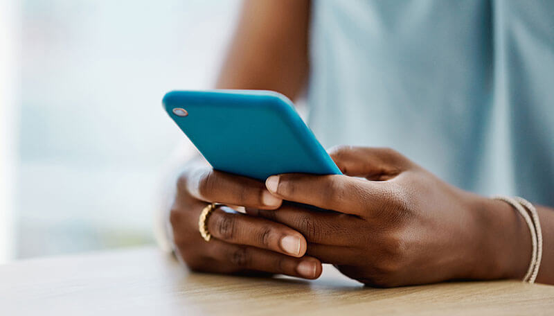 Image of a person's hands holding a blue cellphone