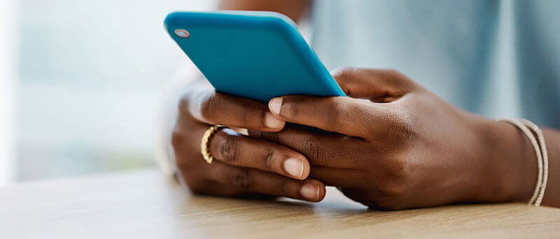 Image of a person's hands holding a blue cellphone